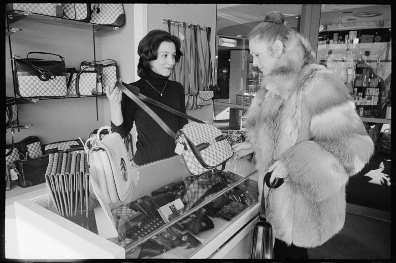 At an unspecified shop in the Watergate complex, a clerk shows a Gucci handbag to a customer dressed in a fur coat, Washington DC, January 3, 1979. (Photo by Thomas J O'Halloran/US News & World Report Magazine Photograph Collection/PhotoQuest/Getty Images)